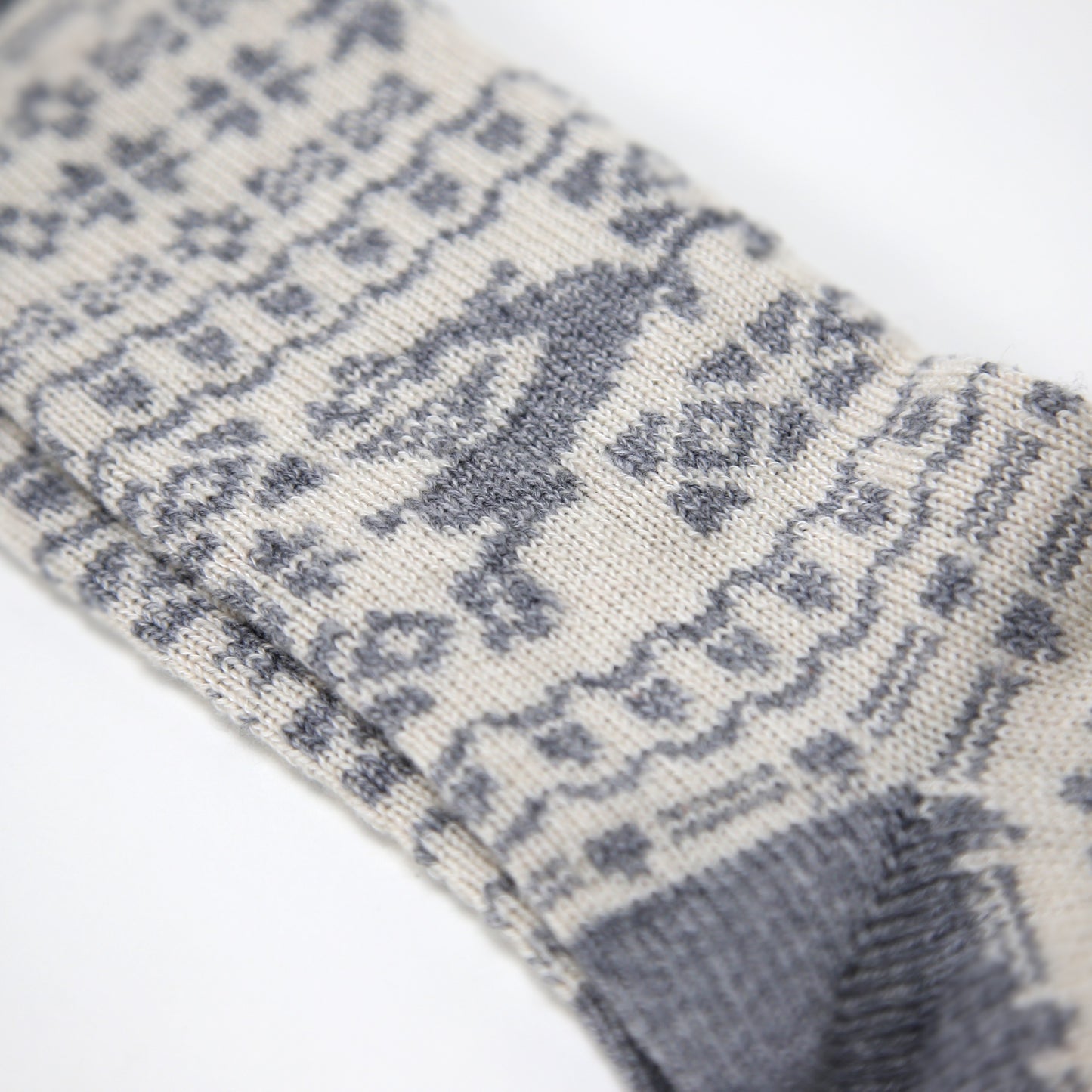 Grey and ecru cream calf length cashmere socks made in the UK. Designed with snowflakes and a leaping deer these cashmere socks are luxury loungewear for women and men
