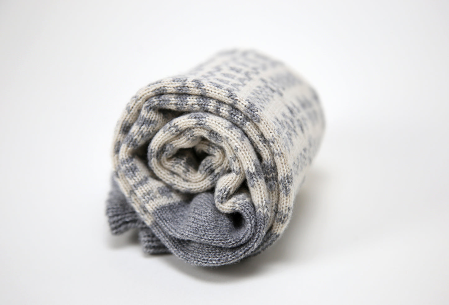 Grey and ecru cream calf length cashmere socks made in the UK. Designed with snowflakes and a leaping deer these cashmere socks are luxury loungewear for women and men
