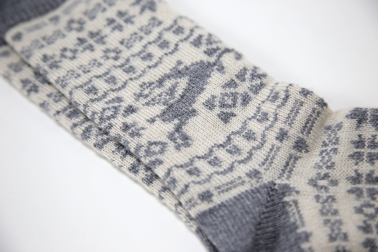 Grey and ecru cream calf length cashmere socks made in the UK. Designed with snowflakes and a leaping deer these cashmere socks are luxury loungewear for women and men